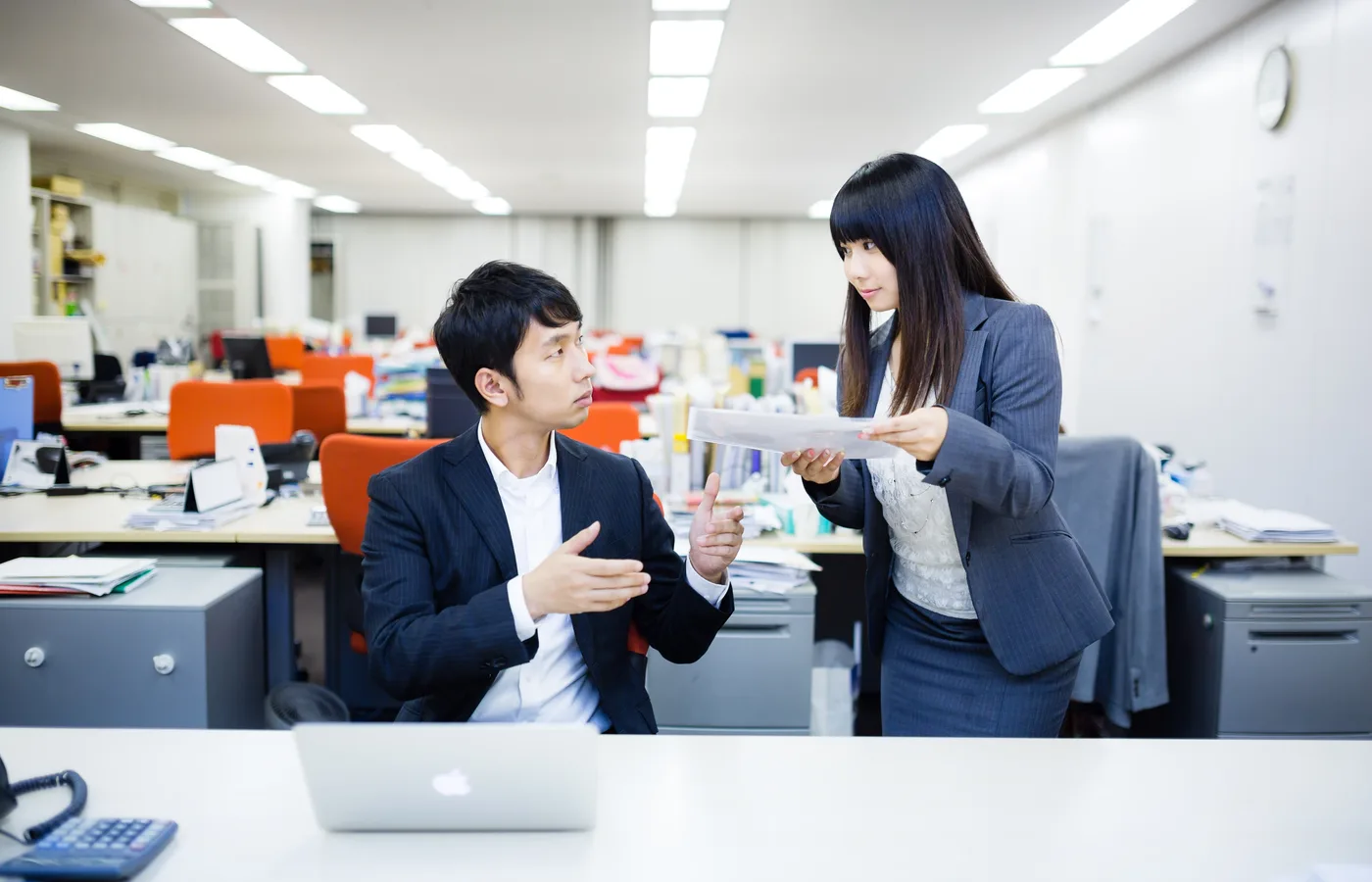 日本人の担当者から書類の説明を受ける様子